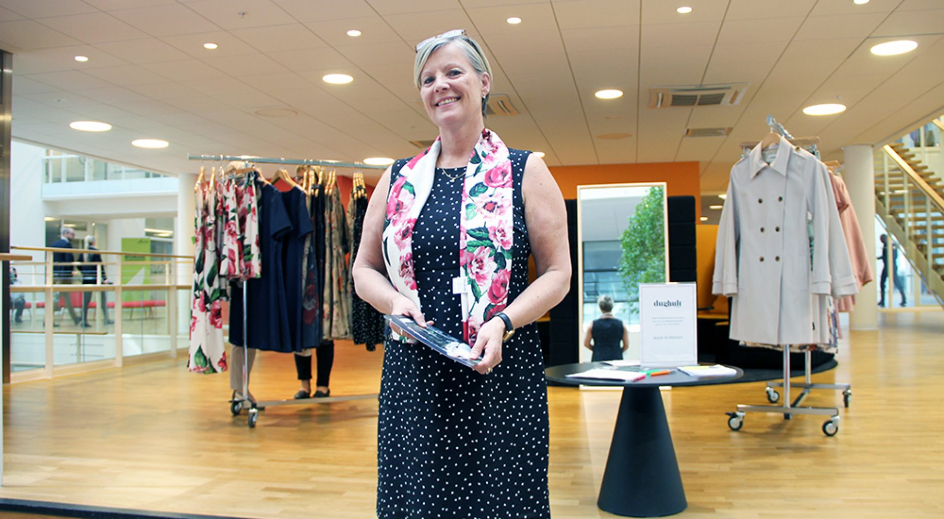 Annika Lundberg, som är försäljningsansvarig på Dughult of Sweden, visar upp några av företagets egendesignade kläder i ljusgården på Kilsgatan 4.