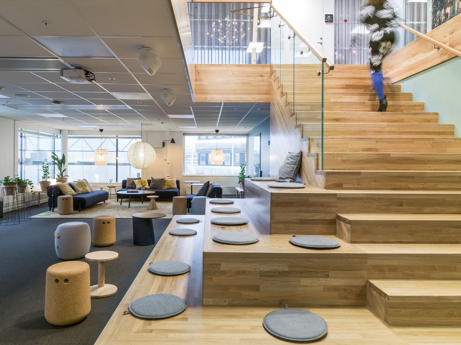 Trappa och gradäng med sittkuddar och kvinna som går i trappan